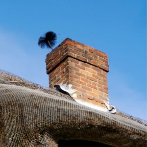 sweeping brush coming out of a masonry chimney