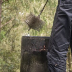 a chimney sweep brush being hovered above a chimney opening
