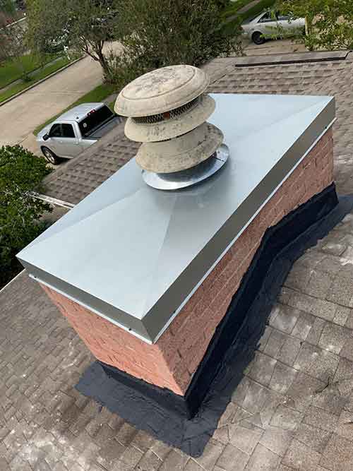 Beautiful new metal chimney crown and flashing where chimney meets roof.