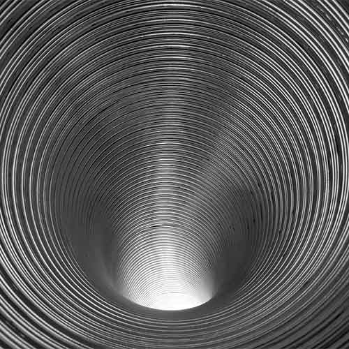 Looking down interior of a ribbed stainless steel chimney liner.