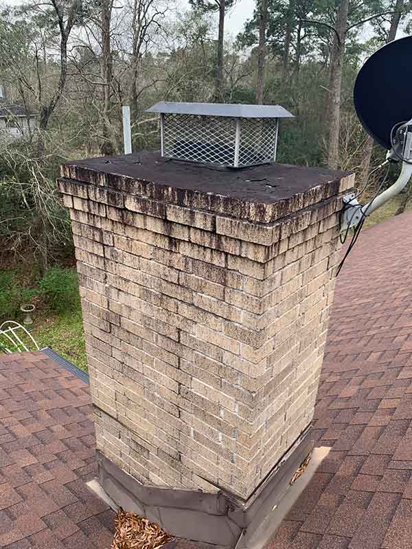 Before clean-up of moldy chimney with damaged crown, creosote and dish attached to side of chimney.