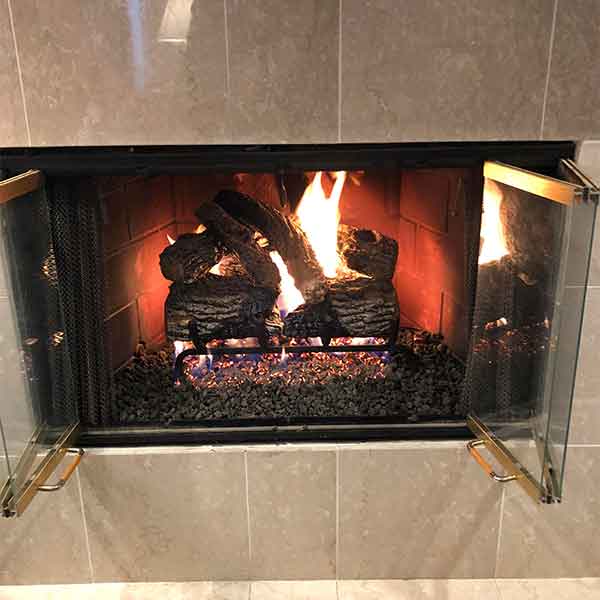 Gas Logs with glass doors, gas conversion, fire in fireplace with large tile surround