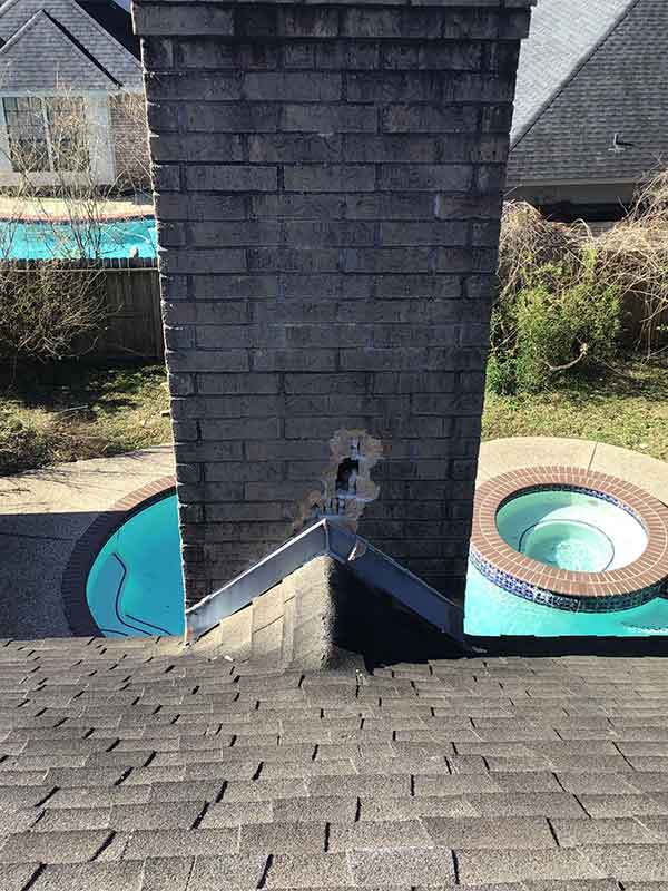Lightning strike at base of chimney where it meets flashing. Hot tub in background as well as an in-ground swimming pool.