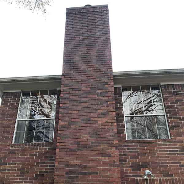 Tall chimney with windows on each side after pressure wash.