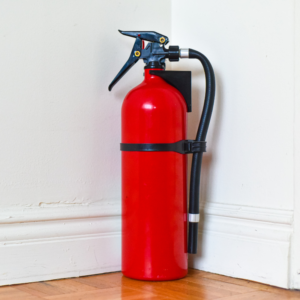 a red fire extinguisher set in a corner