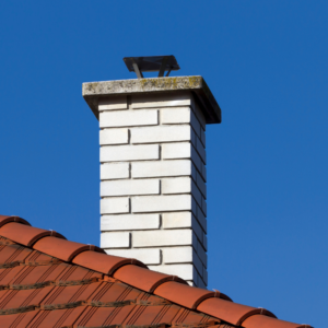 a white masonry chimney against a blue sky