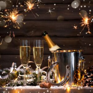 filled wine glasses by an ice bucket with champagne and other New Year's Eve decor