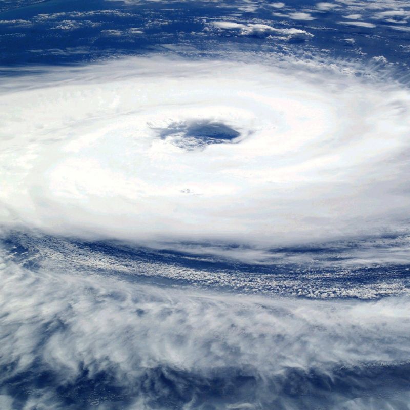 a distant view of a hurricane, a white swirl in a dark blue ocean